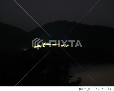 夜明け前の山に浮かぶライトアップされた竹田城跡 142039013