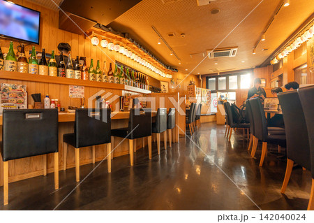 Traditional japanese izakaya restaurant interior with wooden counter and sake bottles in Toshima, Ikebukuro, Tokyo, Japan Traditional japanese izakaya restaurant interior with wooden counter and sake bottles in Toshima, Ikebukuro, Tokyo, Japan 142040024