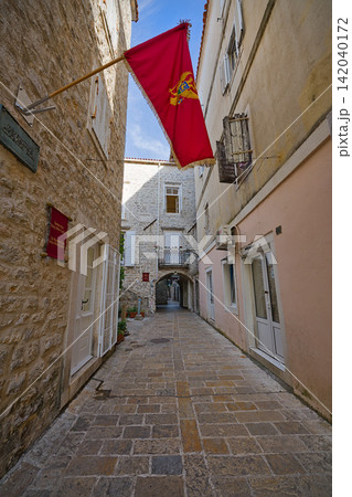 Historic red Venetian flag waving in Budva Old Town alley in Montenegro 142040172
