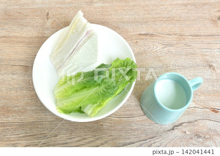 hamcheese sandwich with fresh cos lettuce on plate eat couple fresh milk cup hamcheese sandwich with fresh cos lettuce on plate eat couple fresh milk cup 142041441
