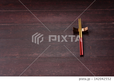 Asian style chopsticks on a dark, empty wooden table. Chopsticks as a food background 142042552