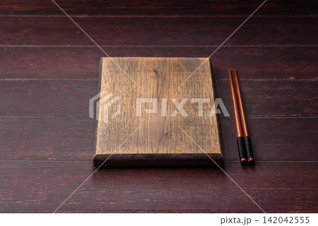 A square wooden cutting board for home food preparation. A wooden cutting board A square wooden cutting board for home food preparation. A wooden cutting board 142042555