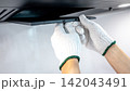 Male hand technician removing range hood filter from modern cooker hood 142043491