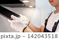 Asian male maintenance worker removing range hood filter from modern cooker hood 142043518