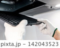 Male hand with protective gloves removing black range hood filter from cooker hood 142043523