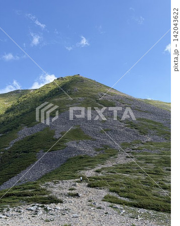 山頂と青空 青空に映える山頂へと続く稜線と登山道の雄大な夏の山岳風景 山頂と青空 青空に映える山頂へと続く稜線と登山道の雄大な夏の山岳風景 142043622