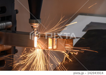 Sparkling flame and sparks from fiber laser cutting machine cutting steel square tube 142043914