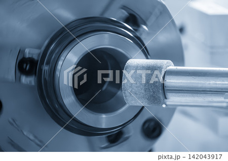Inside surface finishing process on metal part using internal grinding machine in light blue tone 142043917