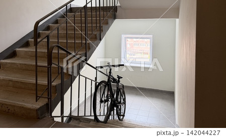 Bicycle parked in apartment building stairwell Bicycle parked in apartment building stairwell 142044227