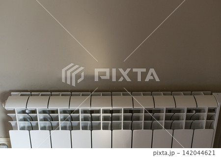 White sectional heating radiator on beige wall with copy space indoors White sectional heating radiator on beige wall with copy space indoors 142044621