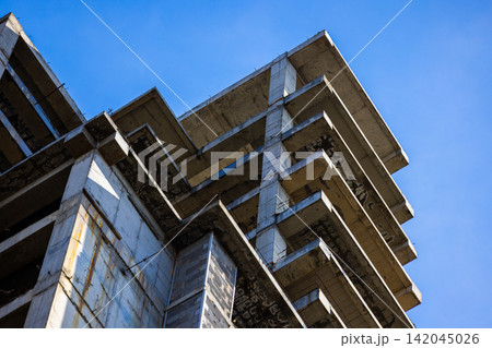 Unfinished Concrete Building Structure Against Blue Sky Unfinished Concrete Building Structure Against Blue Sky 142045026