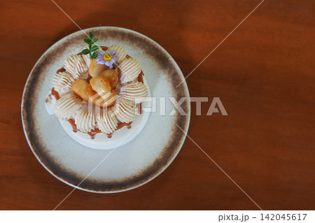 top view mini macadamia caramel and coffee cake and decorated with flowers, whipped cream, and macadamia nuts served on brown and white ceramic plate on wooden floor background, food, dessert, copy top view mini macadamia caramel and coffee cake and decorated with flowers, whipped cream, and macadamia nuts served on brown and white ceramic plate on wooden floor background, food, dessert, copy 142045617