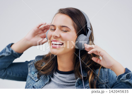 Headphones, dance or happy woman streaming music in studio for singing on grey background to relax. Model, podcast or girl listening to radio playlist, sound or song audio on an online subscription 142045635