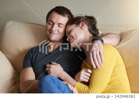 Couple, hug and relax on sofa with love or bonding for romance with affection, security and safety. Man, woman and together in home with care or happiness for comfort, connection and embrace. 142046361
