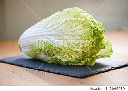 Whole vegetable, fresh and cutting board in kitchen for diet, cooking and wellness. Cabbage, green and natural produce for food, nutrition and vegan in house for salad leaves, food and gut health. Whole vegetable, fresh and cutting board in kitchen for diet, cooking and wellness. Cabbage, green and natural produce for food, nutrition and vegan in house for salad leaves, food and gut health. 142046610