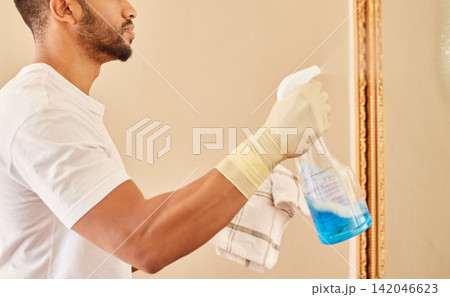 Man, hands and spray bottle for cleaning mirror in home, hotel and cloth to wipe dirt or bacteria. Male person, gloves and chemical for sanitation on glass, maintenance and maid for liquid hygiene 142046623