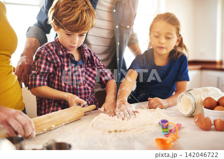 Family, baking and kitchen for fun with learning with child development. Parents, kids and childhood on weekend for bonding with mess at home on table for memories with cookies, children and happy 142046722
