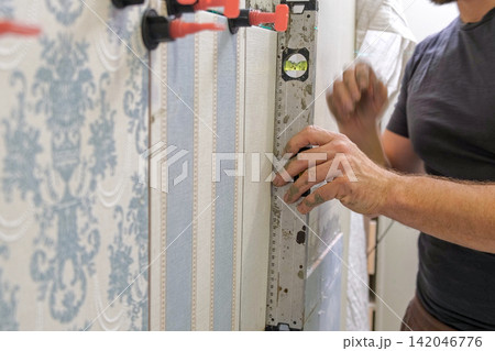 Worker Laying Ceramic Tiles on the Wall. Repairman Placing White Gray Square Tiles, Applying Adhesive. Builder Installing Tile Using Leveler, Tile Leveling Clips. Tiling. Finishing Repair Work. 4K Worker Laying Ceramic Tiles on the Wall. Repairman Placing White Gray Square Tiles, Applying Adhesive. Builder Installing Tile Using Leveler, Tile Leveling Clips. Tiling. Finishing Repair Work. 4K 142046776
