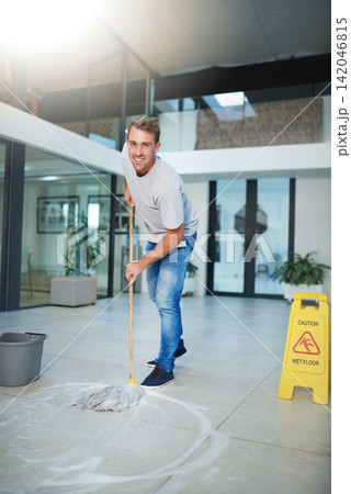 Man, portrait and mopping office floor or cleaning hygiene with caution sign or water, soap or bacteria. Male person, face and smile in corporate building as janitor service or dirty, wellness or job Man, portrait and mopping office floor or cleaning hygiene with caution sign or water, soap or bacteria. Male person, face and smile in corporate building as janitor service or dirty, wellness or job 142046815