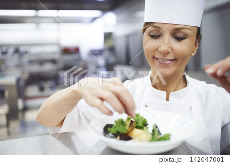 Cooking, food and chef in restaurant with dish presentation for lunch, fine dining and dinner. Kitchen, serving and woman with seasoning, plating and ingredients for culinary, cuisine and catering Cooking, food and chef in restaurant with dish presentation for lunch, fine dining and dinner. Kitchen, serving and woman with seasoning, plating and ingredients for culinary, cuisine and catering 142047001