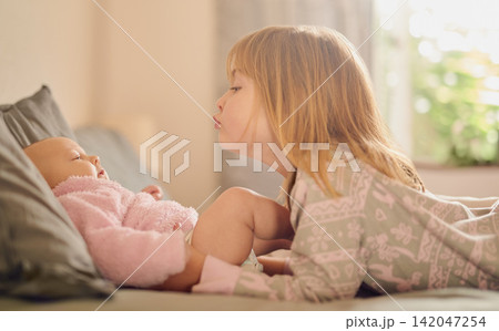 Family, love and sister kissing baby girl on bed in home together for care, relationship or support. Bedroom, children and youth with sibling kids bonding in apartment for child development or growth 142047254
