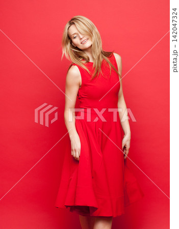 Woman, dress and fashion in studio with red background with trendy for clothing with confidence. Apparel, couture and glamour or chic with runway model for catwalk in New York with pride in color Woman, dress and fashion in studio with red background with trendy for clothing with confidence. Apparel, couture and glamour or chic with runway model for catwalk in New York with pride in color 142047324