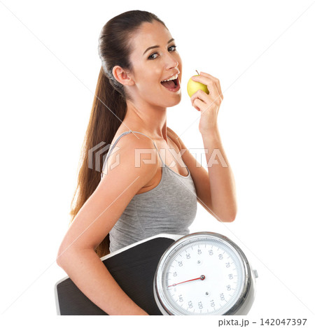 Woman, scale and smile with apple in studio on white background for body weight, progress and fat loss with fitness. Portrait, happy and healthy with diet or nutrition for self care and health 142047397