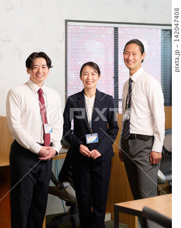 オフィスで並んで笑顔を見せる3人の会社員 オフィスで並んで笑顔を見せる3人の会社員 142047408