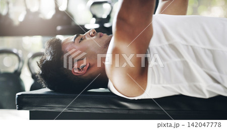 Bench press, weights and man in gym for fitness, bodybuilder training and exercise. Sports, athlete and person with equipment for strong muscles do workout for performance, wellness and strength Bench press, weights and man in gym for fitness, bodybuilder training and exercise. Sports, athlete and person with equipment for strong muscles do workout for performance, wellness and strength 142047778