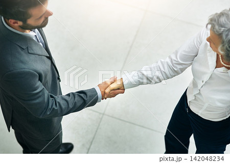 Business people, handshake and meeting with partnership for b2b, greeting or agreement about at office. Top view of businessman, woman or employees shaking hands for teamwork or deal at workplace Business people, handshake and meeting with partnership for b2b, greeting or agreement about at office. Top view of businessman, woman or employees shaking hands for teamwork or deal at workplace 142048234