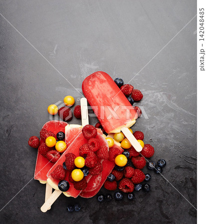 Popsicles, blueberries and fruit for tasty summer treat, snack or frozen dessert in studio background. Fresh, ice lolly and collection of food on counter top for nutrition, diet and yummy eating Popsicles, blueberries and fruit for tasty summer treat, snack or frozen dessert in studio background. Fresh, ice lolly and collection of food on counter top for nutrition, diet and yummy eating 142048485