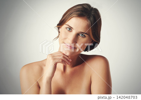 Smile, confidence and face of woman for skincare, beauty and dermatology with happiness isolated on gray background. Hand, skin and model natural with glow, wellness and soft on studio backdrop 142048703