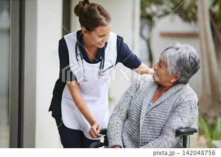 Senior woman and wheelchair at nursing home with carer for assistance in closeup, help at clinic. Disabled retiree and medical or outdoors for talk or plan for healthcare, conversation with nurse Senior woman and wheelchair at nursing home with carer for assistance in closeup, help at clinic. Disabled retiree and medical or outdoors for talk or plan for healthcare, conversation with nurse 142048756