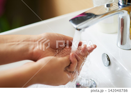 Water, sink and person washing hands in house for cleaning, safety and hygiene at home. Splash, liquid and palm for prevention of dirt, bacteria or germs in bathroom with finger disinfection process 142048786