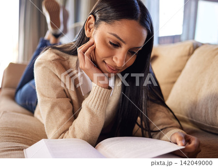College student, relax and girl reading book in home for university, research or school education. Learning, knowledge and Indian woman with scholarship or novel on sofa studying academic information 142049000