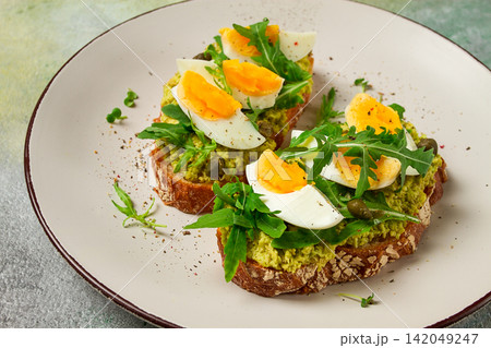 sandwich with mashed avocado, boiled egg, and arugula, on bread , homemade, breakfast, 142049247