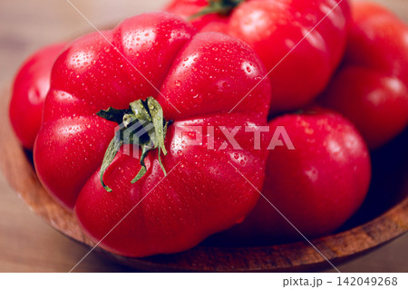 Pink tomatoes, in a rustic wooden bowl, close-up, no people, 142049268