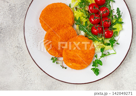 crispy fried fish cutlets, fish burgers, on a white plate, with fresh lettuce leaves, arugula and cherry tomatoes, homemade, no people, 142049271