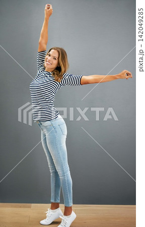 Woman, happy and home fashion or relax, casual and carefree or stretch for freedom and smile. Standing, grey wall and portrait in jeans with confident girl, weekend and comfort style or outfit Woman, happy and home fashion or relax, casual and carefree or stretch for freedom and smile. Standing, grey wall and portrait in jeans with confident girl, weekend and comfort style or outfit 142049285