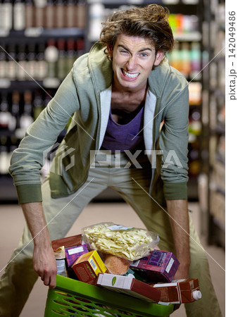 Man, basket and groceries in store with stress, inflation and retail for nutrition, wellness and health. Male shopper, struggle and anxiety as customer in food, increase and prices for purchase Man, basket and groceries in store with stress, inflation and retail for nutrition, wellness and health. Male shopper, struggle and anxiety as customer in food, increase and prices for purchase 142049486