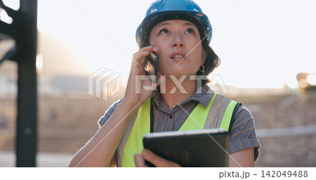 Asian woman, phone call and tablet, construction worker and inspection of building site for project management. Architecture, engineer and communication, contractor and affirmative action outdoor 142049488