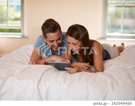 Happy, bed and couple on tablet laughing for comedy, streaming subscription and watching movies. Home, bedroom and man and woman on digital tech for online videos, connection and relax on weekend Happy, bed and couple on tablet laughing for comedy, streaming subscription and watching movies. Home, bedroom and man and woman on digital tech for online videos, connection and relax on weekend 142049489