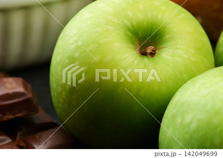 Closeup, healthy or apple for diet in kitchen of home on counter for diet, natural vitamin c or nutrition. Vegan, background or fruit with sweet chocolate in apartment or house for detox or minerals 142049699