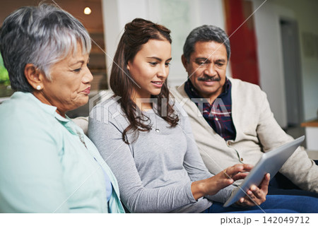 Senior parents, woman and tablet in living room for connection or bonding with technology. Family, home and mature people with young, female person and happy for togetherness on couch in community Senior parents, woman and tablet in living room for connection or bonding with technology. Family, home and mature people with young, female person and happy for togetherness on couch in community 142049712