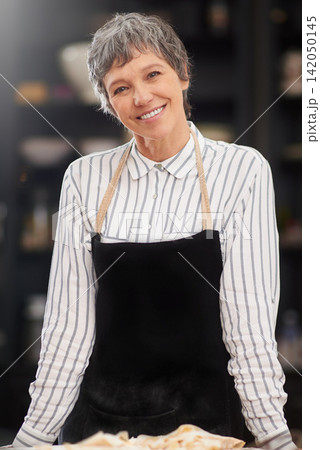 Chef, bakery and portrait of mature woman with smile, apron and cooking for meal prep with confidence. Lunch, nutrition and happy face of baker at kitchen counter for pride, small business and pastry Chef, bakery and portrait of mature woman with smile, apron and cooking for meal prep with confidence. Lunch, nutrition and happy face of baker at kitchen counter for pride, small business and pastry 142050145