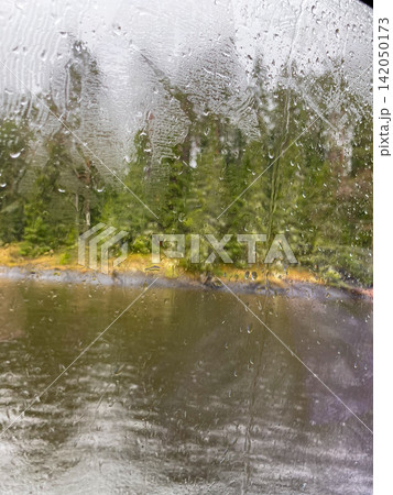 Rainy Forest Lake Through Wet Window Rainy Forest Lake Through Wet Window 142050173