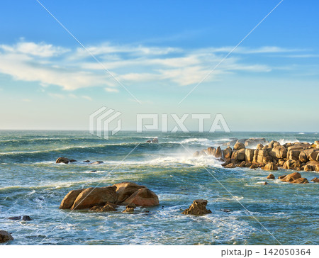 Ocean, waves and rocks on coast of beach in Malaysia for outdoor travel in summer for vacation or holiday. Sea, beachrocks and blue sky with landscape for wallpaper or background, water and nature 142050364
