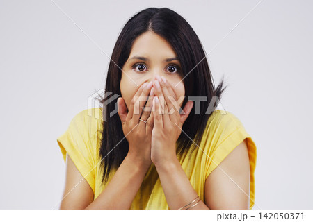 Shock, gossip and portrait of woman in studio for fake news, announcement or mistake with worry. Surprise, emotion and person with hands on mouth for wow, omg or wtf expression by gray background. Shock, gossip and portrait of woman in studio for fake news, announcement or mistake with worry. Surprise, emotion and person with hands on mouth for wow, omg or wtf expression by gray background. 142050371