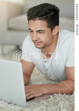 Man, laptop and student for education in home, floor and browse for research on college project. Male person, lounge and university website for course, assignment and app for study or online class Man, laptop and student for education in home, floor and browse for research on college project. Male person, lounge and university website for course, assignment and app for study or online class 142050389