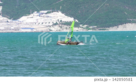 Novorossiysk Russia July 05 2026 Young man securing a personal watercraft onto a trailer at the shoreline on a sunny day Novorossiysk Russia July 05 2026 Young man securing a personal watercraft onto a trailer at the shoreline on a sunny day 142050581